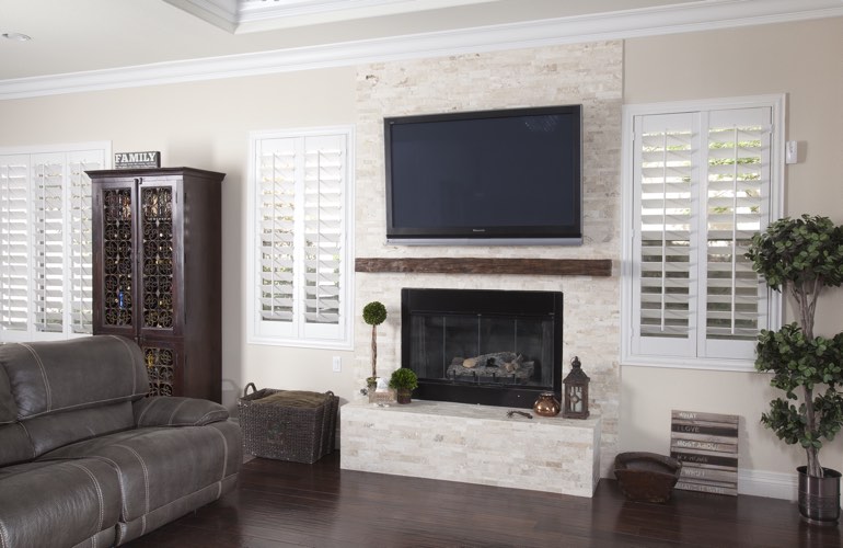White plantation shutters in a Miami living room with plank hardwood floors.